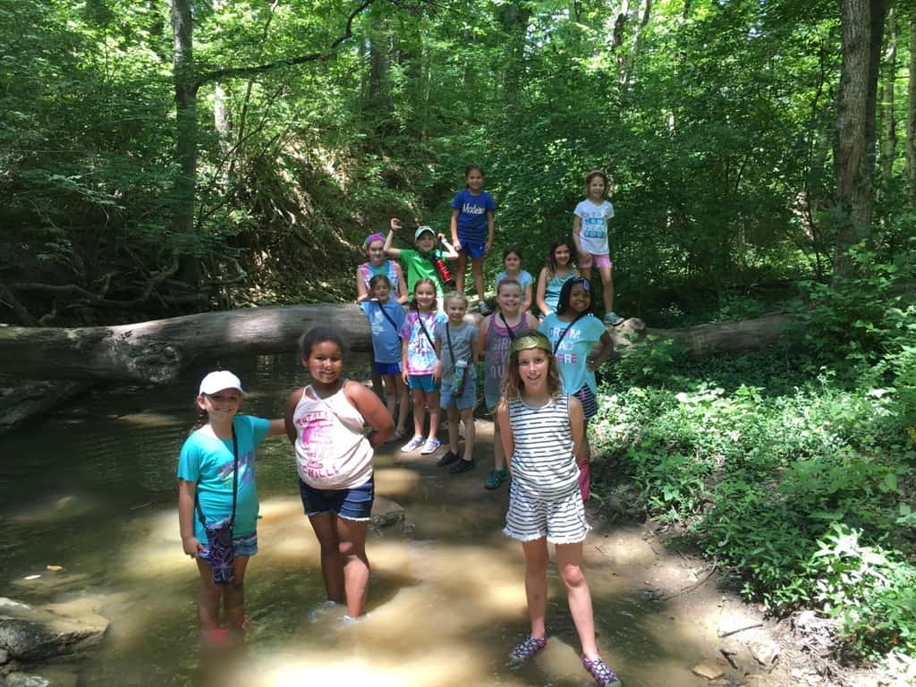 Girl Scout camp day 3 started off with our girls leading the rest of camp in the opening flag ceremony. After that, the day flew by with a talk about graphic design, cards for a service project, a nature scavenger hunt, sun s'mores, a group skit, a spider web craft, singing, creek time, hiking, and more!